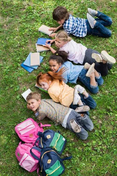 Enfants lisant des livres dans le parc — Photo de stock