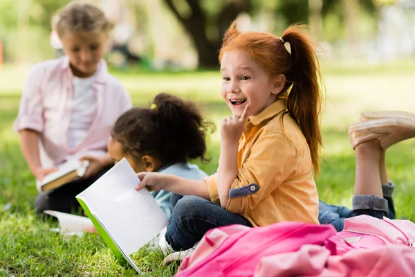 Enfants lisant des livres dans le parc — Photo de stock