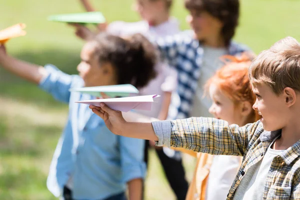 Niños jugando con aviones de papel - foto de stock