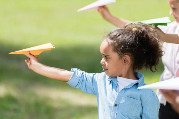 Niños jugando con aviones de papel - foto de stock