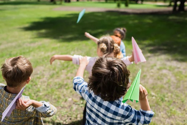 Niños jugando con aviones de papel - foto de stock