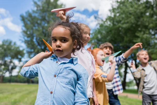 Niños jugando con aviones de papel - foto de stock