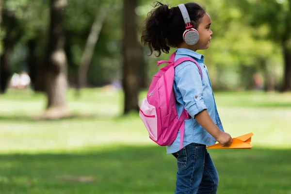 Colegiala afroamericana en auriculares - foto de stock