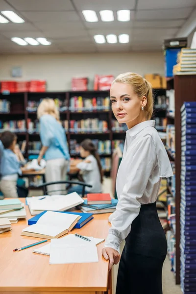 Junge Lehrerin in der Bibliothek — Stockfoto