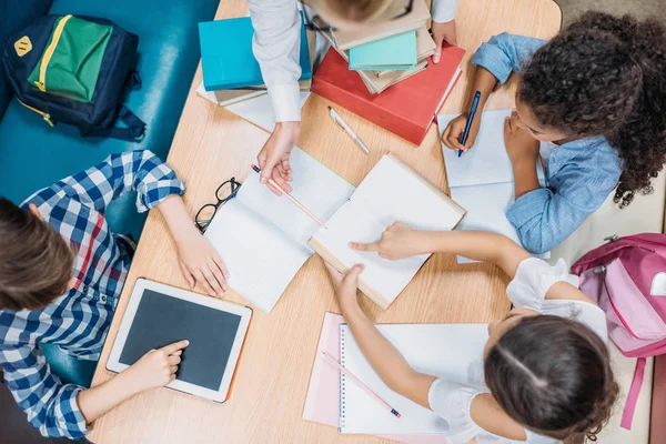 Teacher and pupils doing homework — Stock Photo