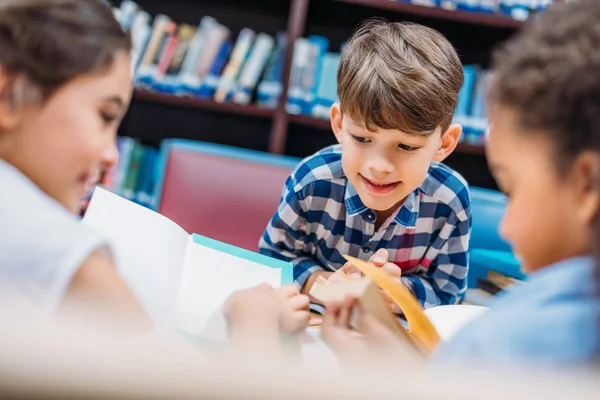 Crianças lendo livros na biblioteca — Fotografia de Stock