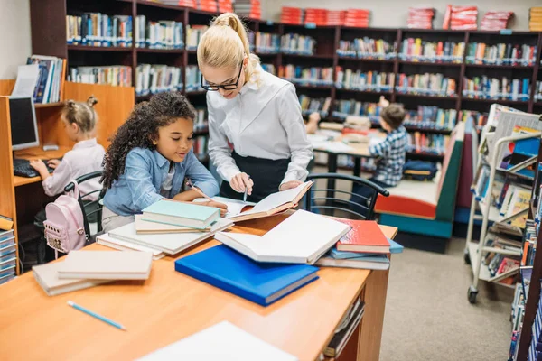 Professeur avec enfants à la bibliothèque — Photo de stock