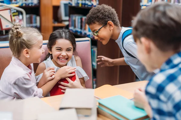 Niños divertidos en la biblioteca - foto de stock