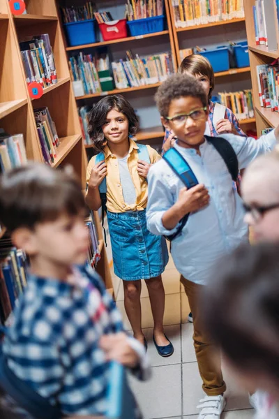 Niños pequeños en la biblioteca - foto de stock