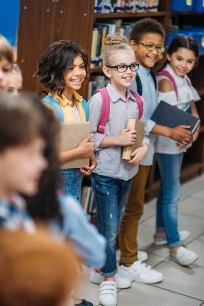 Mignons enfants dans la bibliothèque — Photo de stock