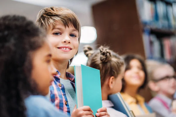 Bambini con libri in biblioteca — Foto stock