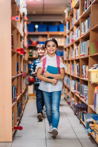 Niños con libros en la biblioteca - foto de stock