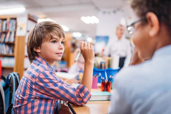 Meninos de escola falando na biblioteca — Fotografia de Stock