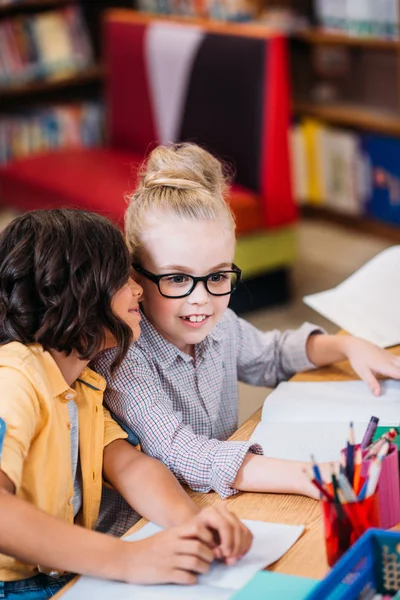 Mädchen tratschen in Bibliothek — Stockfoto