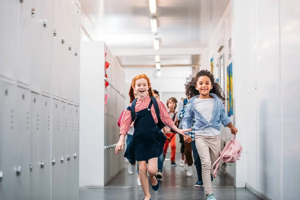 Alunni che corrono attraverso il corridoio scolastico — Foto stock