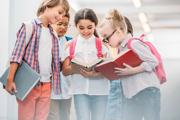 Happy scholars looking at book — Stock Photo