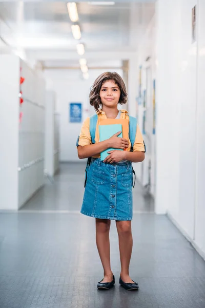 Schoolgirl with backpack and book — Stock Photo
