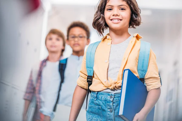 Scolaretta con zaino e libro e ragazzi — Foto stock