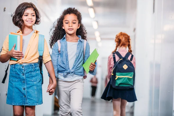 Niñas caminando por el pasillo de la escuela - foto de stock