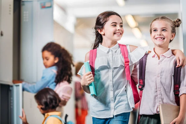 Colegialas caminando por el pasillo de la escuela - foto de stock