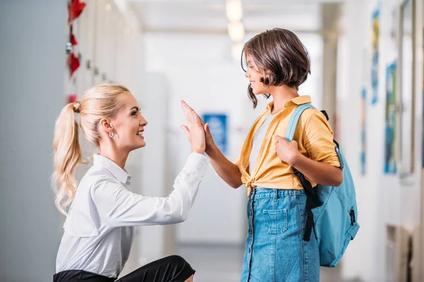 Lehrerin gibt Schulmädchen High Five — Stockfoto