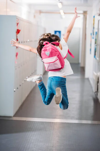 Girl jumping in school corridor — Stock Photo