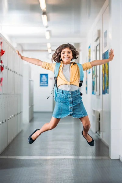 Fille sautant dans le couloir scolaire — Photo de stock