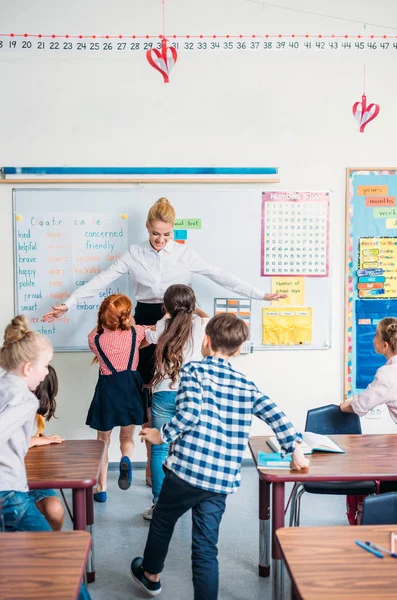 Teacher embracing with pupils — Stock Photo