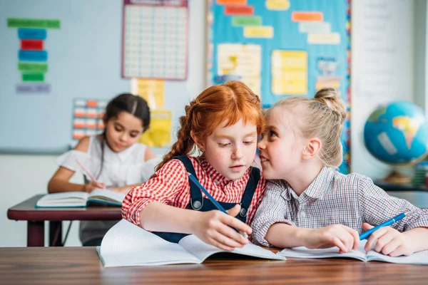 Kleine Mädchen tratschen im Unterricht — Stockfoto