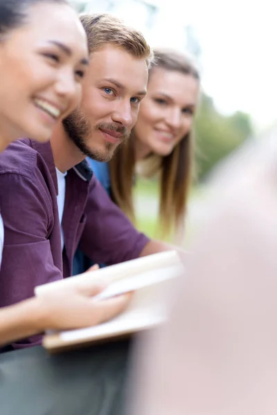 Estudiantes multiétnicos con libro - foto de stock