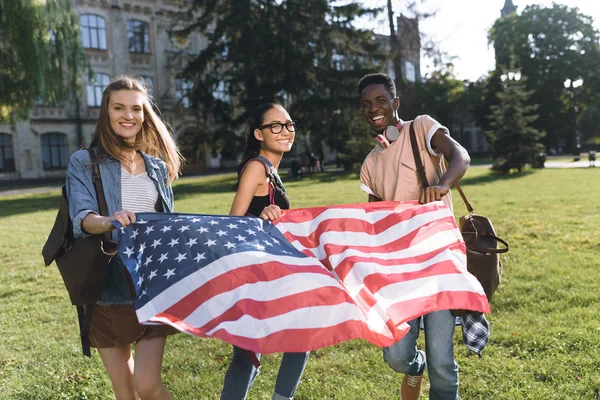 Amigos multiculturales con bandera americana - foto de stock