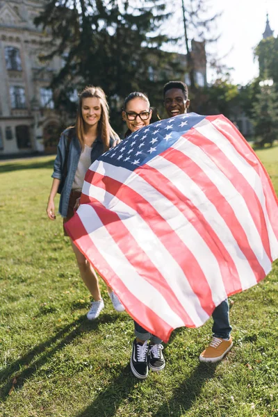 Мультикультурные друзья с американским флагом — стоковое фото