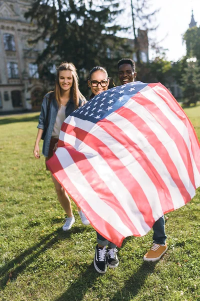 Amigos multiculturales con bandera americana - foto de stock