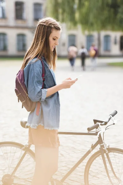 Fille en utilisant smartphone dans le parc — Photo de stock