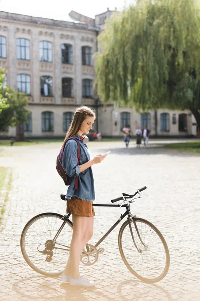 Fille en utilisant smartphone dans le parc — Photo de stock