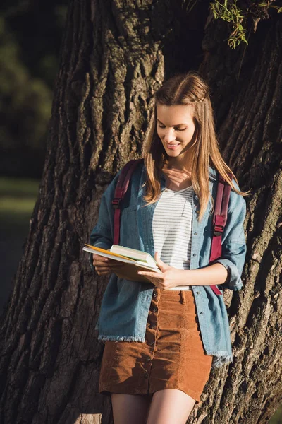 Chica joven con libros en el parque - foto de stock