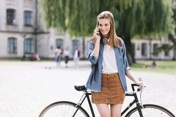 Girl talking by phone in park — Stock Photo