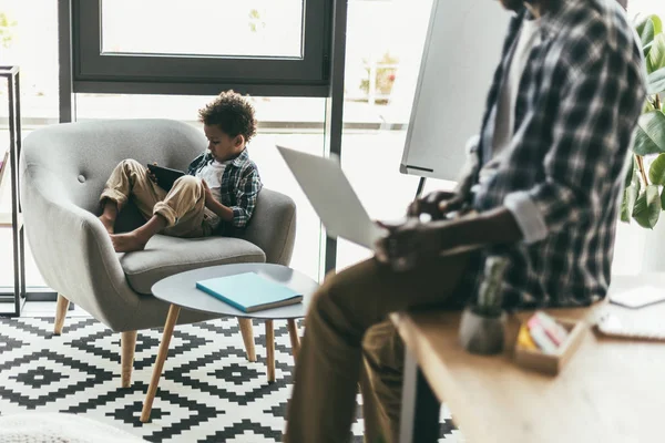 Father and son using gadgets — Stock Photo