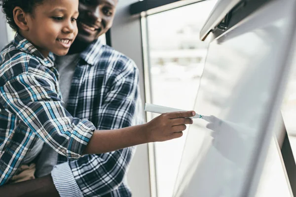 African-american father and son with whiteboard — Stock Photo