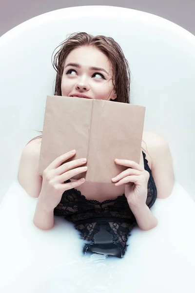 Mulher com livro deitado no banho — Fotografia de Stock