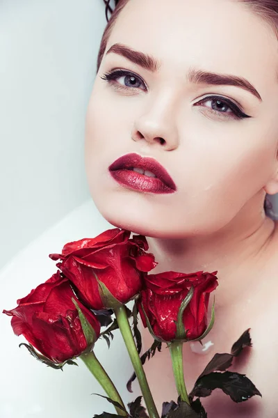 Frau mit roten Rosen — Stockfoto