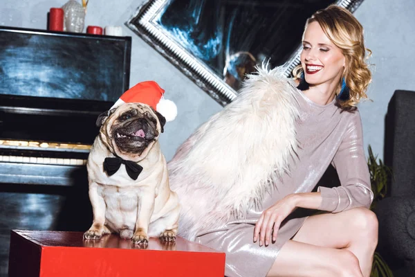 Woman with pug in santa hat — Stock Photo