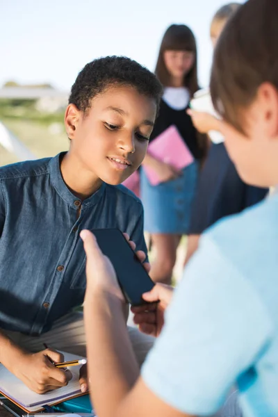 Multiethnic boys using smartphone — Stock Photo