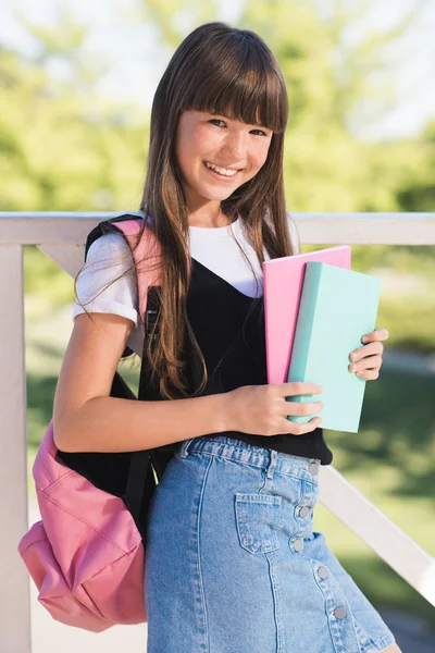 Adolescente sorridente con libri — Foto stock
