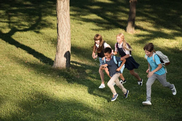 Adolescentes multiétnicos corriendo en el parque - foto de stock