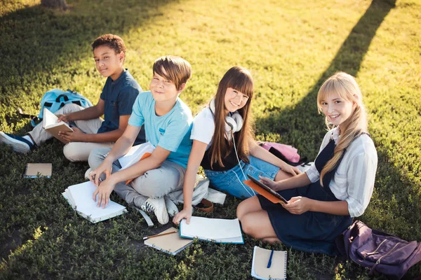Multiethnic teenagers studying in park — Stock Photo