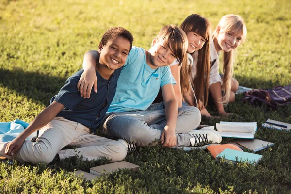 Multiethnic teenagers studying in park — Stock Photo