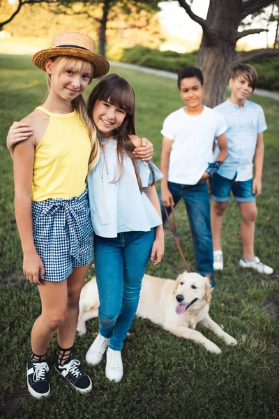 Teenagers with dog in park — Stock Photo