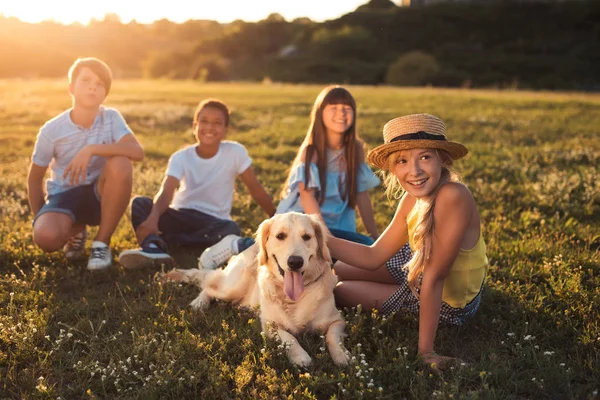 Teenagers with dog in park — Stock Photo