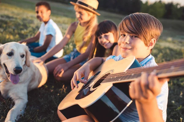 Multiethnic teenagers with guitar — Stock Photo